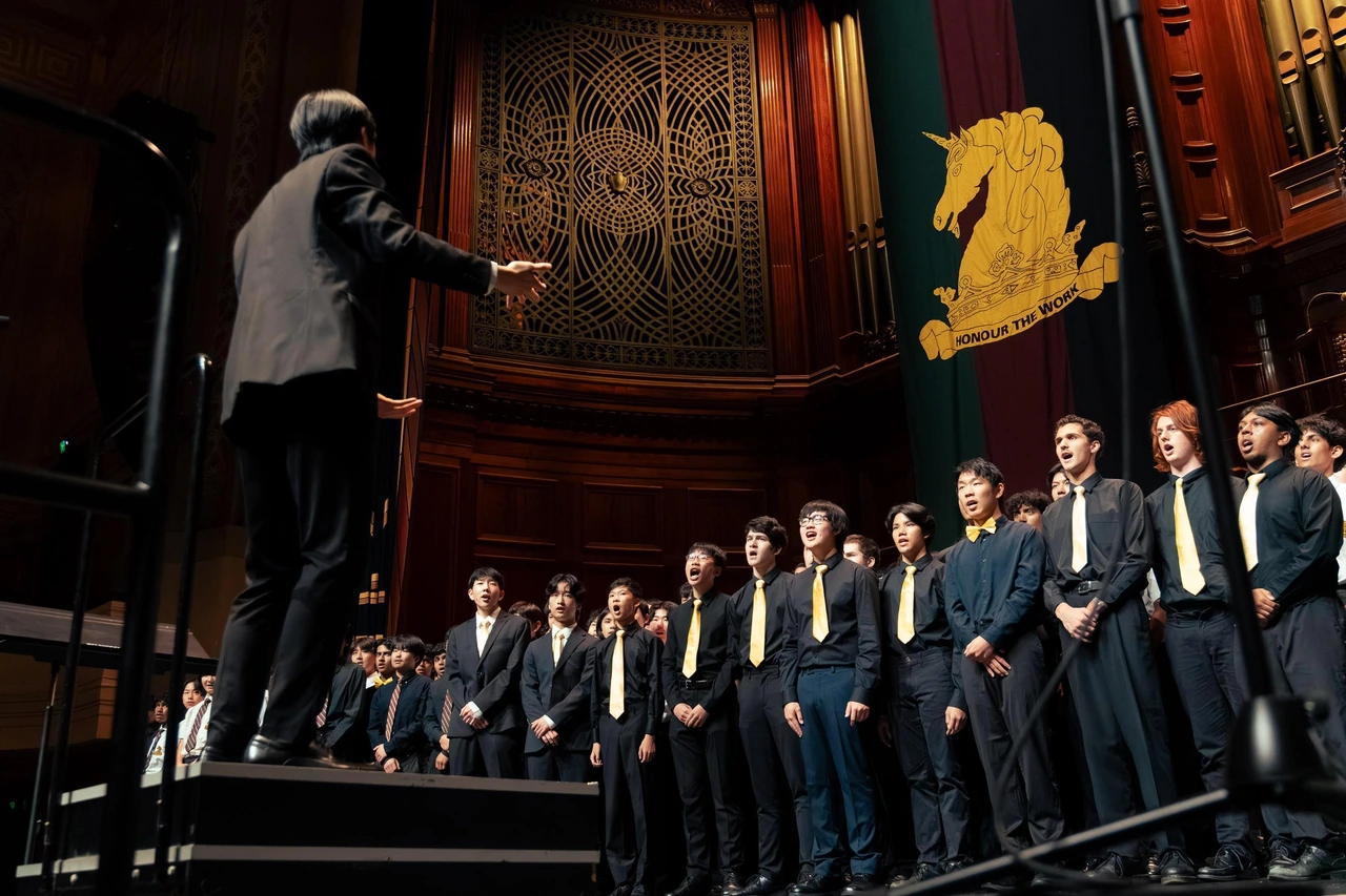 Isaac conducting the Melbourne High School choir in an ornate hall